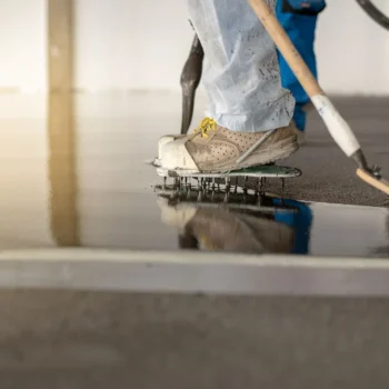 worker applying concrete finish in industrial building